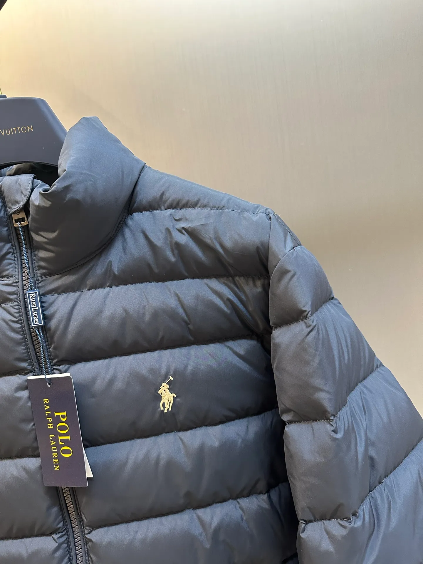 P890 Ralph Lauren lightweight down jacket. The nylon fabric has good windproof and waterproof properties, which can effectively block the intrusion of wind and rain from the outside and keep the inside dry. It is suitable for wearing in humid or rainy environments. The red label on the chest is made with an imported MECLO embroidery machine. The original pattern is scanned first, and then high-quality silk thread is used to make a pattern. The density effect is adjusted by continuous pattern making.  The zipper design is simple and elegant, easy to operate, and the closing design of the cuffs and hem effectively prevents cold wind from invading, improving the warmth and comfort of wearing. It uses 90 white duck down with a weight of 260g to ensure excellent thermal insulation performance. After strict screening and processing, the velvet is not easy to drill, ensuring durability. size: s m l xl